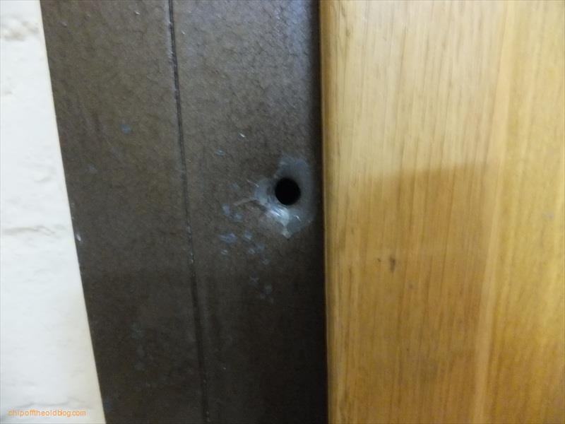 Bullet hole in apartment door next to hotel